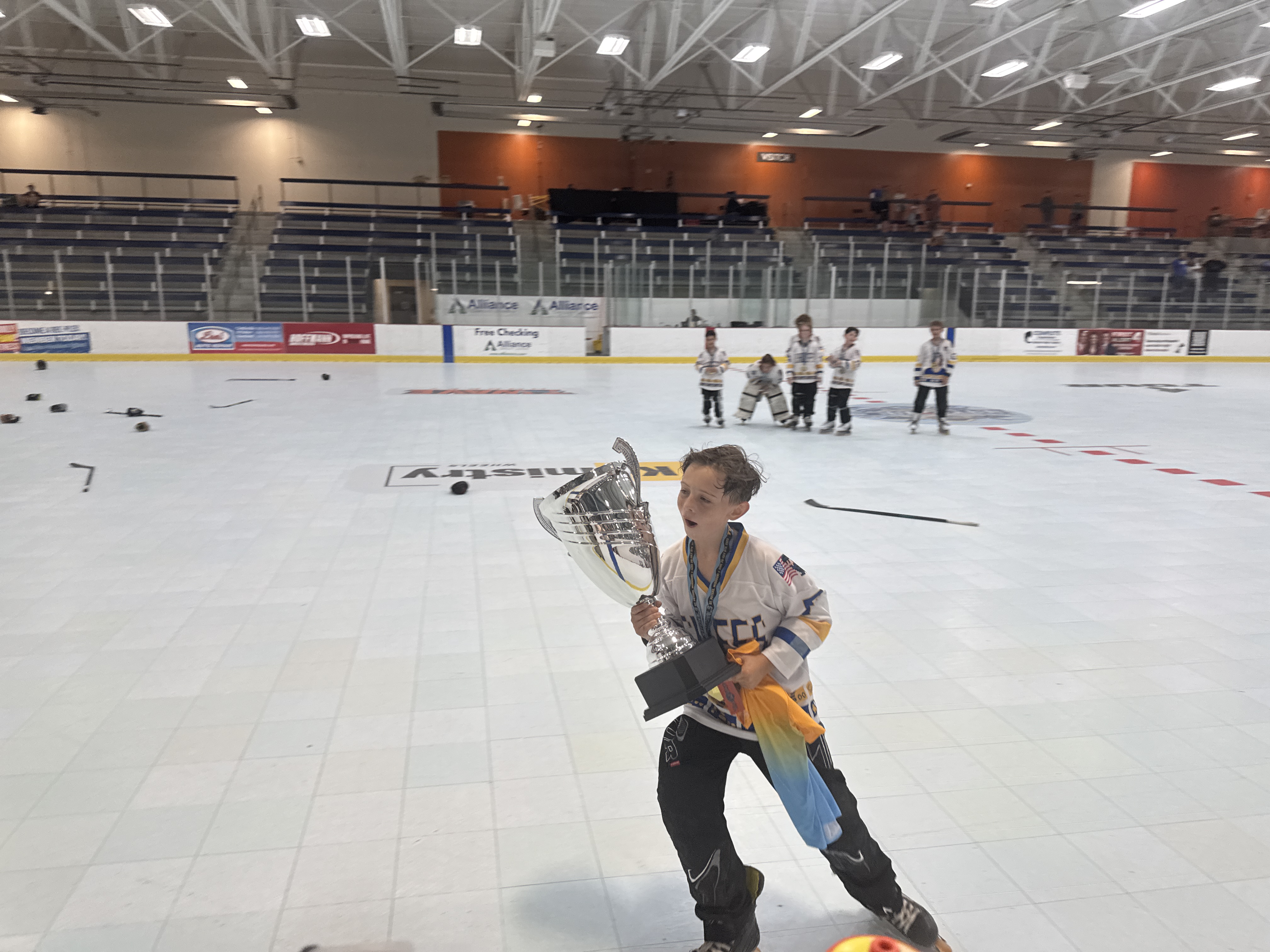Young player skating with the championship trophy at TORHS Nationals